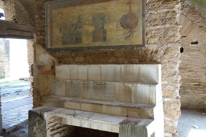 Ancient Ostia Antica Semi-Private Day Trip from Rome by Train with Guide - Shops, apartments, temples, and public life